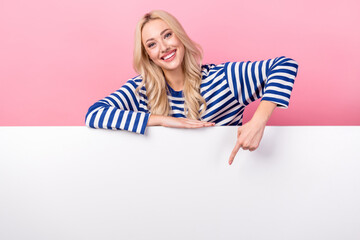 Poster - Photo of young optimistic woman wear striped pullover point finger empty space presentation apple store isolated on pink color background