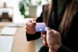 © Studio Marmellata - Unrecognizable male sharing credit card with anonymous female colleague while sitting at wooden desk together and preparing for online payment in modern workspace