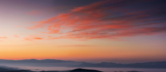 Wall Mural - panorama of heavens at dawn. clouds in red and orange colors of a rising sun on a blue sky