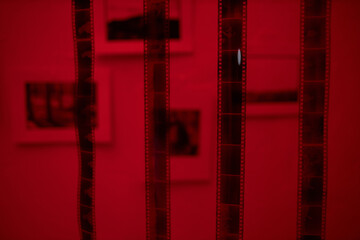 Close-up of photo film hanging in darkroom with red lighting