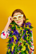 © bondarillia - A joyful teenager girl wearing a colorful Brazil carnival mask