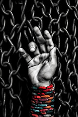 Fototapete -  A black and white photograph of a person's hand reaching out from behind a lattice of chains, Generative AI technology.