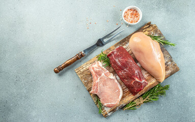 Wall Mural - raw meat assortment steaks beef, pork, chicken on light background. place for text, top view