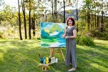 Laughing Young Woman With Huge Canvas Outside In Nature Painting Landscape Scene