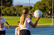 © Austockphoto - school kids practising netball on outdoor court