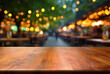 © oksa_studio - Empty wooden table and abstract blurred background of coffee shop or restaurant outdoor.