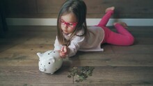 Child Collects Money In Piggy Bank. Girl Learns To Invest Money, Saving, Piggy Bank And Little Girl.