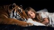A beautiful child girl lying next to a cute tame tiger.