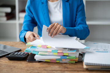 Poster - Close up view of busy young businesswoman working with stack of papers and document in her office room.