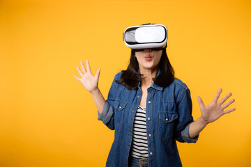 Poster - Young asian woman get experienced wearing virtual reality headset game entertainment isolated on yellow background. Winner of cyber future video game concept.