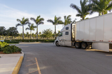 A white truck with a white trailer parked on the side of the road in Florida 