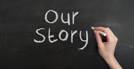 Aufkleber - A woman's hand write text Our story with chalk on chalkboard