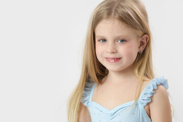 Wall Mural - Studio headshot of beautiful 5 years old girl with blue eyes and long blonde hair