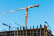 © Dmitry Presnyakov - A construction crane on a blue sky background. Construction site. Lifting crane.