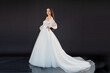 © alipko - Beautiful fashion bride posing in wedding dress on black background