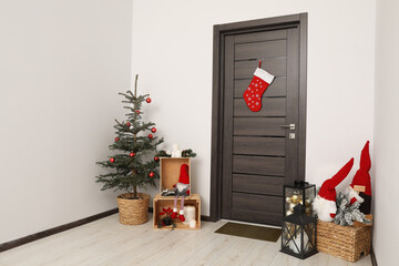 Wall Mural - Christmas stocking hanging on wooden door and festive decoration indoors