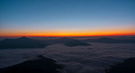 Wall Mural - Beautiful landscape on the mountains against sky during sunrise. Spectacular view in foggy valley covered forest under morning sky. Countryside landscape view background.