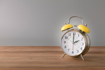 Wall Mural - Retro silver alarm clock. 2:00.  am,  pm. Neutral background. Brown wood surface. Horizontal  photography with empty space for text or image.