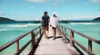© Terrence W/peopleimages.com - Travel, freedom and rear view of couple at beach walking, holding hands and relax on ocean jetty with blue sky background. Summer, holiday and behind man with woman at sea, traveling or Bali romance