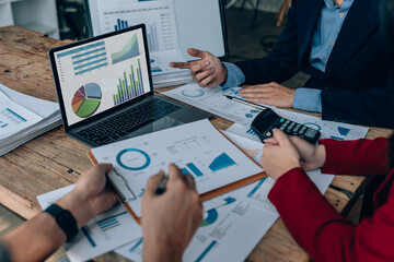 Two business people meeting to talking or discuss marketing work in workplace using paperwork, calculator, computer to work