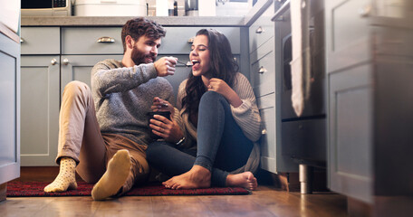 Poster - Ice cream, kitchen and couple on floor in home for bonding, relaxing and quality time together. Love, relationship and happy man and woman with sweet treats, dessert and luxury snack for romance