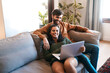 © Emil Lime/peopleimages.com - Relax, love and laptop with couple on sofa for happy, social media and streaming. Smile, internet and subscription with man and woman online in living room at home for network, news and website