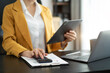 © NINENII - Business women or accountant working on laptop computer with business document, graph diagram and calculator on office table in office.