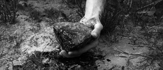 Fototapeta bloodied hand with big stone