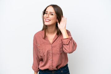 Wall Mural - Young pretty caucasian woman isolated on white background listening to something by putting hand on the ear