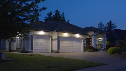 Wall Mural - Establishing shot of two story stucco luxury house with garage door, big tree and nice landscape at night in Vancouver, Canada, North America. Night time on Apr 2023. ProRes 422 HQ.