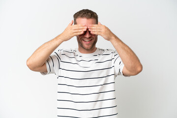 Wall Mural - Young handsome caucasian man isolated on white background covering eyes by hands and smiling