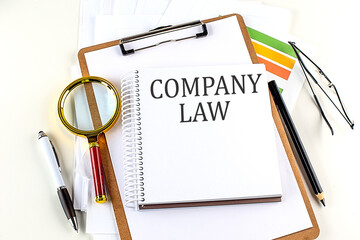 Poster - COMPANY LAW text on notebook with clipboard on white background