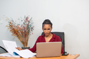 Wall Mural - beautiful young african lady busy with work in her office