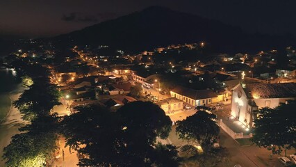 Wall Mural - Aerial view of the coastal town of Santo Antonio de Lisboa in Brazil during night time. Footage has high level of noise