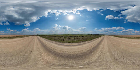 Wall Mural - spherical 360 hdri panorama on edge of gravel road with clouds and sun on blue sky in equirectangular seamless projection, use as sky replacement in drone panoramas, game development as sky dome