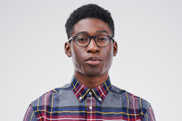 Face portrait, serious geek and black man in studio isolated on white background. African, nerd and male person with glasses from South Africa with fashion, style and pose with clothes for confidence