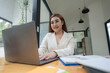 © Songsak C - Asian Businesswoman working on a laptop at her desk at the office.