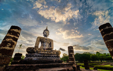 Wide view of sitting Buddha at sunset with blue sky and white cloud on background. UNESCO and World Heritage site. Travel concept.