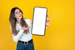 Holding smartphone, caucasian young girl holding smartphone. Portrait of beautiful woman presenting close up image of empty blank screen mobile phone mockup.  Mobile application advertisement concept.