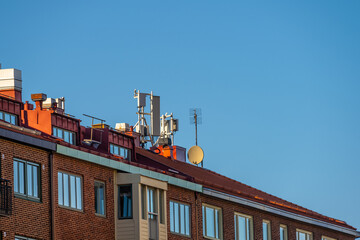 Wall Mural - Telecommunications antennae on the top of a apartment building roof.