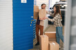 © Viacheslav Yakobchuk - Young couple with big cardboard boxes into warehouse with self storage unit