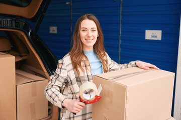 Wall Mural - Portpait of young woman with big cardboard boxes and scotch