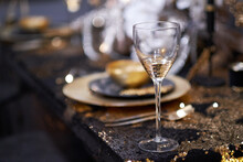 Christmas Table Setting With Plates, Silverware, Gift Box And Decorations In Black And Gold Colors