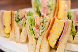 Fototapeta Tęcza - Japanese sandwich with omelette, ham, tomato, lettuce, cucumber and sauces in a cafeteria.