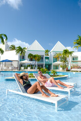 Wall Mural - Luxury resort with swimming pool near Palm Beach Aruba Caribbean, couple man and woman mid age on a luxury vacation in the Caribbean