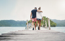 Couple, Vacation And Walking On Ocean Boardwalk For Travel, Freedom And Peace. Back Of A Man And Woman Hug And Walk To Relax On Indonesia Holiday, Tropical Adventure Or Nature Date At Sea On A Deck