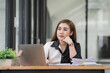 © Songsak C - Attractive young Asian businesswoman thinking and looking out the window.
