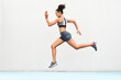 © Emil Lime/peopleimages.com - Woman, fitness and running on mockup of athlete in cardio training, workout or healthy exercise. Fit, active or sporty female person or runner exercising for health and wellness on wall mock up space