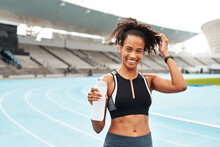 Fitness, Running And Portrait Of Happy Woman With Water At Stadium, Relax At Marathon Training Or Exercise. Workout, Health And Body, Female Sports Runner At Arena Track With Smile And Bottle.