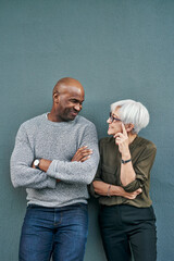 Canvas Print - Professional, talking and wall with blue background have a discussion at work with a friend. Man, woman and business, friendship on outdoor have a conversation about commitment and teamwork.